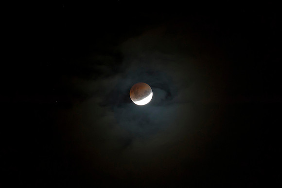 The blood moon through clouds & and space.